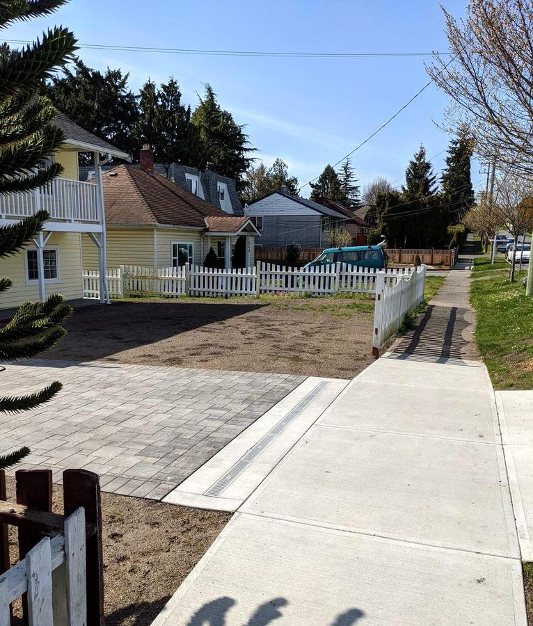 Finished concrete curb, sidewalk and slot trench drain with paver driveway transition in Esquimalt, BC