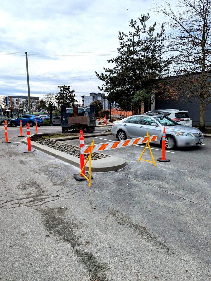 Completed concrete curb island with rock bed in a Langford commercial parking lot
