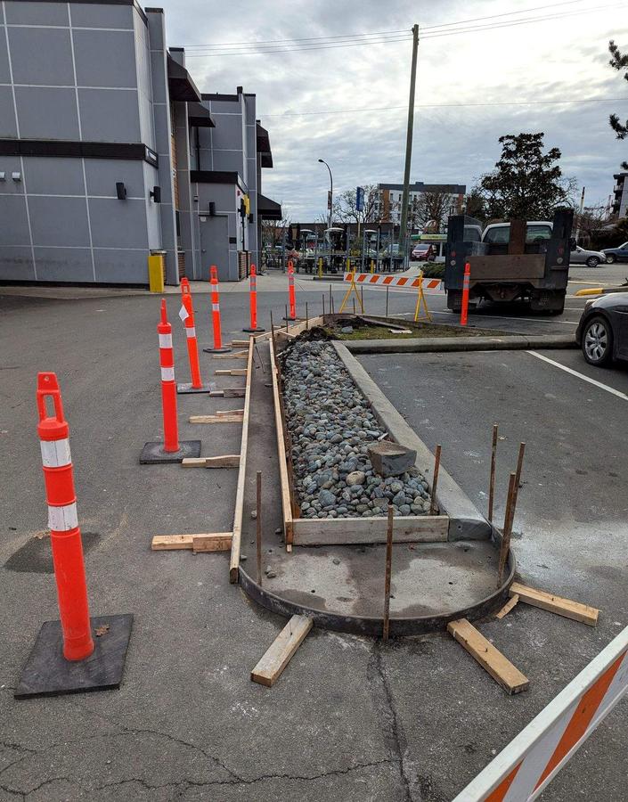 Formwork around a rock planter bed before a curb pour at a Langford commercial site