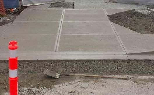 Finished concrete sidewalk and twin driveway aprons for an infill townhouse development in Victoria, BC