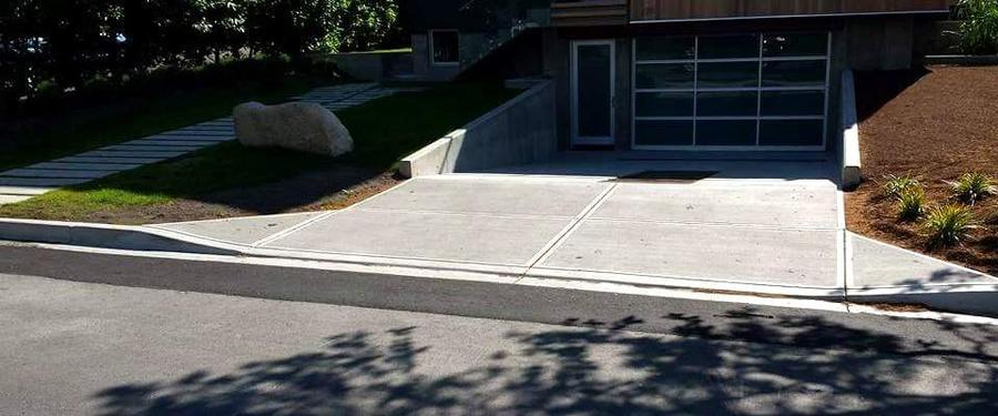 Finished non-mountable concrete curb with attached driveway apron at a modern home in Victoria, BC